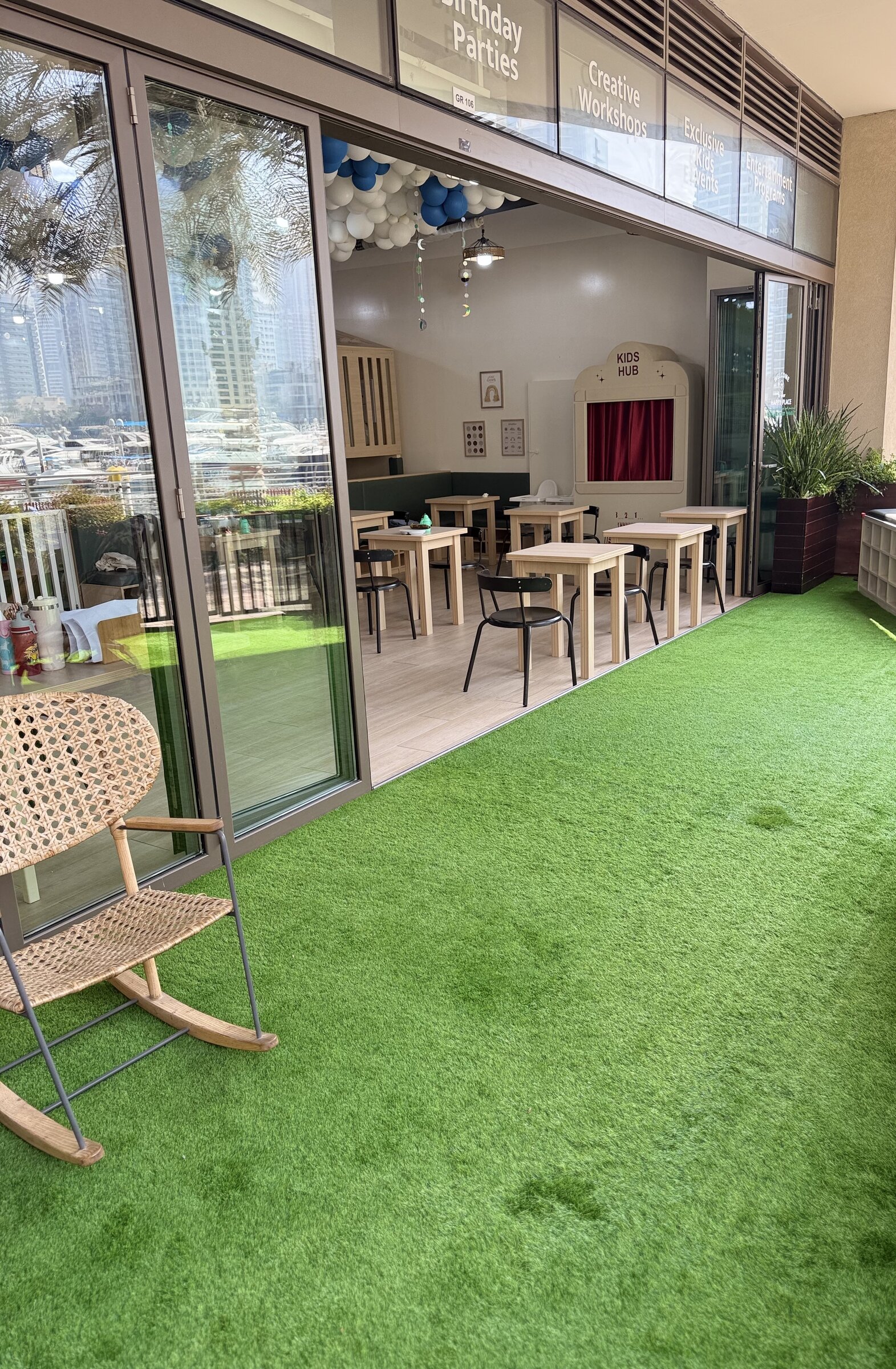 Kids Hub terrace entrance with artificial grass at Marina Gate 2