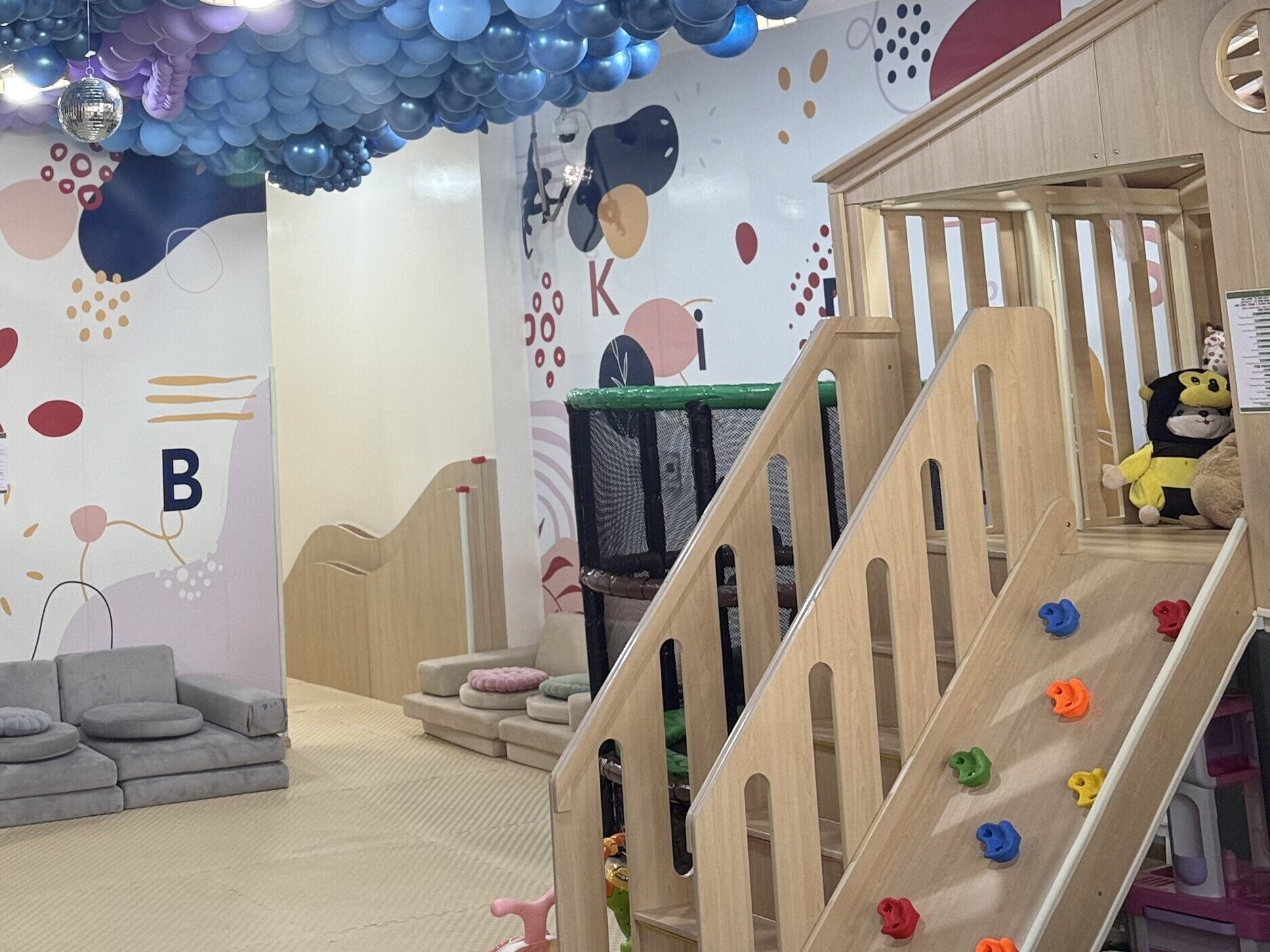 Kids Hub indoor play area with balloon ceiling and climbing playhouse